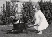 Girl with toys in wheelbarrow
